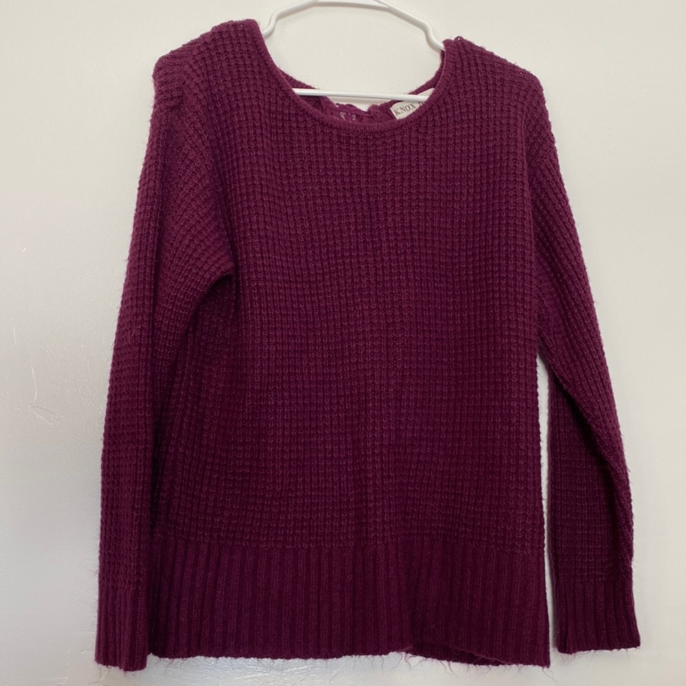 A purple sweater with a cut out in the back. Size medium